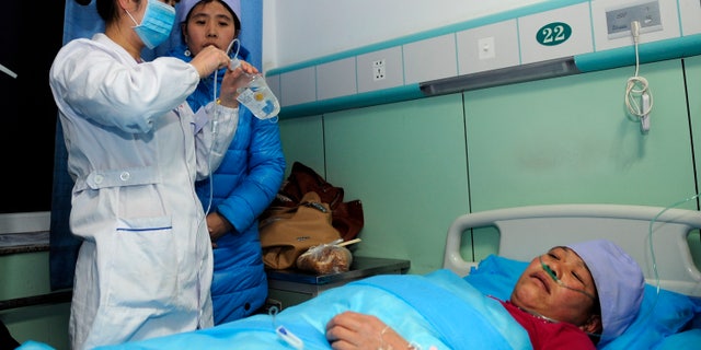 In this Sunday, Jan. 5, 2014 photo provided China's official Xinhnua News Agency, an injured woman receives medical treatment at a hospital in Xiji Town of Guyuan, northwest China's Ningxia region. China's Xinhua News Agency said Monday, Jan. 6, 14 people were killed in a stampede at a mosque in the country’s north and 10 other people were injured in the incident in Guyuan. (AP Photo/Xinhua, Li Ran) NO SALES