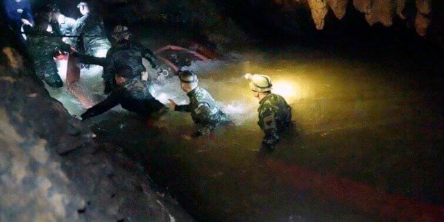 In this handout photo released by Tham Luang Rescue Operation Center, Thai rescue teams walk inside a cave complex in Mae Sai, Chiang Rai province, in northern Thailand, Monday, July 2, 2018.