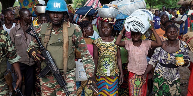 A Cameroonian United Nations peacekeeping soldier guards women fleeing the village of Zike as they arrive to the village of Bambara, Central African Republic, April 25, 2017. Picture taken April 25, 2017. REUTERS/Baz Ratner TPX IMAGES OF THE DAY - RTS143AS
