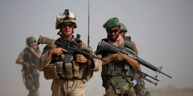 FILE: U.S. Marine squad leader Sgt. Matthew Duquette, left, of Warrenville, Ill., with Bravo Company, 1st Battalion 5th Marines walks with Afghan National Army Lt. Hussein, during in a joint patrol in Nawa district, Helmand province, southern Afghanistan.
