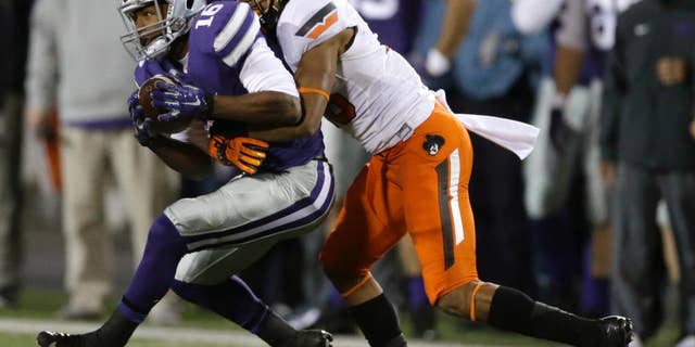 Kansas State wide receiver Tyler Lockett (16) is tackled by Oklahoma State cornerback Ramon Richards (18) during the first half of an NCAA college football game in Manhattan, Kan., Saturday, Nov. 1, 2014. (AP Photo/Orlin Wagner)