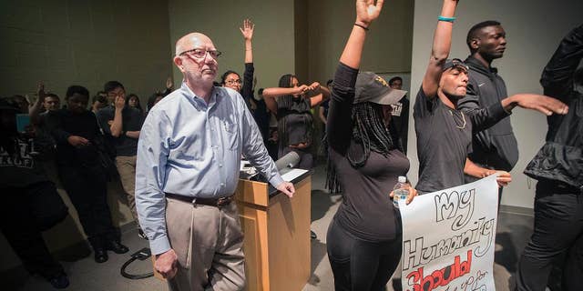 St. Olaf College President David R. Anderson is surrounded by student protesters in the Tomson Hall auditorium on campus in Northfield, Minn. May 1, 2017