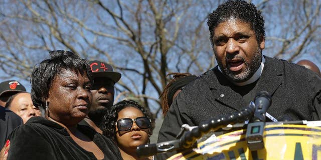 FILE - In this March 1, 2016, file photo, The Rev. William Barber II, right, head of the North Carolina National Association for the Advancement of Colored People, speaks during a news conference as Rolonda Byrd, left, who says she is the mother of shooting victim Akiel Denkins, listens near the scene of a shooting in Raleigh, N.C. Barber and the Rev. James Forbes said Monday, March 28, 2016, that they want to encourage people to reclaim political discourse so that it focuses on love, justice and mercy. (AP Photo/Gerry Broome)