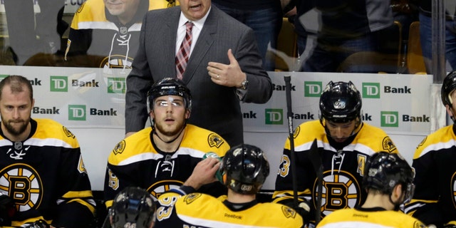 Boston Bruins head coach Claude Julien, standing center, talks with his players during a timeout against the New York Rangers during the third period in Game 5 of the Eastern Conference semifinals in the NHL hockey Stanley Cup playoffs in Boston, Saturday, May 25, 2013. (AP Photo/Charles Krupa)