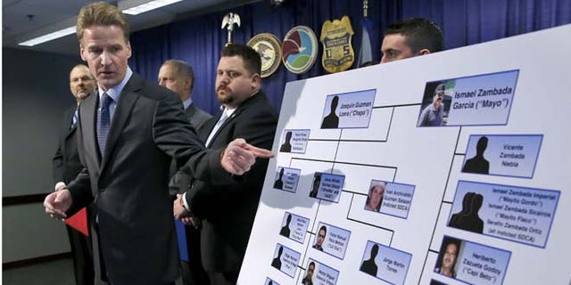U.S. Attorney Zachary T. Fardon makes reference to a chart of know Mexico-based Sinaloa Cartel members, during a news conference after twin brothers Pedro and Margarito Flores were sentenced to 14 years for their drug related activities in the cartel, Tuesday, Jan. 27, 2015, in Chicago. Fardon characterized the Flores brothers cooperation in bringing down the cartel as extraordinary. He says their reduced sentences should illustrate to criminals that, "You can right some of what you did wrong, by helping the government." (AP Photo/Charles Rex Arbogast)