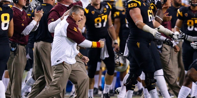 Arizona State coach Todd Graham, left, pumps his fist as he celebrates a defensive stop against Arizona during the second half of an NCAA college football game Saturday, Nov. 30, 2013, in Tempe, Ariz. Arizona State defeated Arizona 58-21. (AP Photo/Ross D. Franklin)