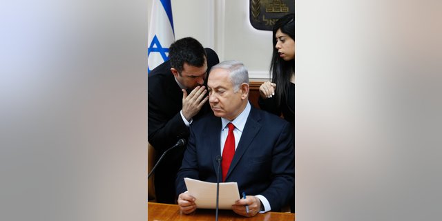 FILE - In this July 23, 2018 file photo, Israeli Prime Minister Benjamin Netanyahu listens to his spokesman David Keyes as he opens the weekly cabinet meeting at his Jerusalem office. An opposition Israeli lawmaker is calling on Netanyahu to suspend Keyes following sexual assault allegations. Michal Rozin, a legislator with the dovish Meretz party, says David Keyes, Netanyahu's spokesman to the foreign media, can no longer represent Israel to the world amid the accusations. (Gali Tibbon/Pool via AP, File)