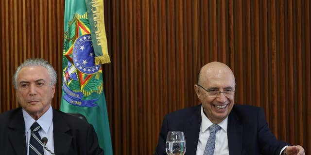 Brazil's acting President Michel Temer, left, presides over his first cabinet meeting, at the Planalto presidential palace in Brasilia, Brazil, Friday, May 13, 2016. Newly named Finance Minister Henrique Meirelles is pictured at right. (AP Photo/Eraldo Peres)