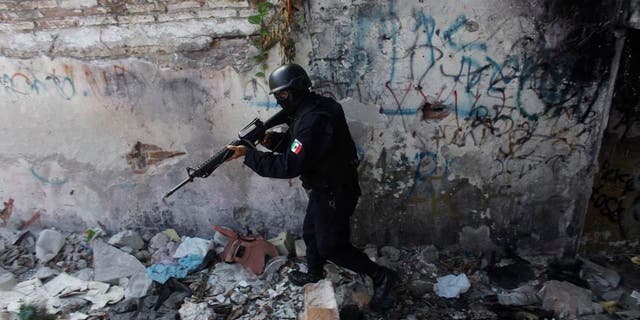 A state police officer belonging to a newly formed elite group participates in a patrol during a preventive surprise search at a low-income neighborhood in the Pacific resort city of Mazatlan, Mexico. (AP Photo/Dario Lopez-Mills)