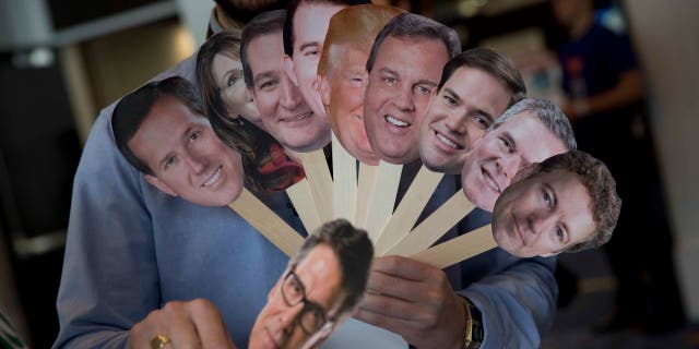 Adam Gabbatt of The Guardian newspaper holds images of possible Republican candidates, from left, former Pennsylvania Sen. Rick Santorum, former Alaska Gov. Sarah Palin, Sen. Ted Cruz, R-Texas, Wisconsin Gov. Scott Walker, Donald Trump, New Jersey Gov. Chris Christie, Sen. Marco Rubio, R-Fla., former Florida Gov. Jeb Bush, Sen. Rand Paul, R-Ky., and, former Texas Gov. Rick Perry, bellow, as he interviews Howard "Cowboy" Woodward during the Conservative Political Action Conference (CPAC) in National Harbor, Md., Thursday, Feb. 26, 2015. (AP Photo/Carolyn Kaster)