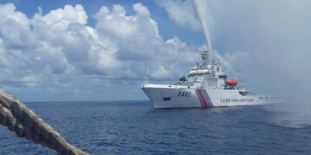 FILE - In this Sept. 23, 2015, file photo, Chinese Coast Guard members approach Filipino fishermen as they confront each other off Scarborough Shoal in the South China Sea, also called the West Philippine Sea. The Philippines' new president said Tuesday July 5, 2016, that Manila is ready to talk to China, not go to war, if an arbitration tribunal rules in its favor in a case it brought against Beijing's claims in the South China Sea. (AP Photo/Renato Etac, File)