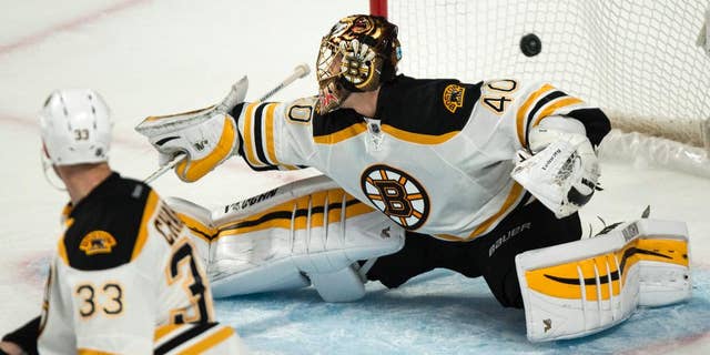The puck flies over Boston Bruins goalie Tuukka Rask on a goal by Montreal Canadiens' P.A. Parenteau during second-period NHL hockey game action Thursday, Oct. 16, 2014, in Montreal. (AP Photo/The Canadian Press, Paul Chiasson)