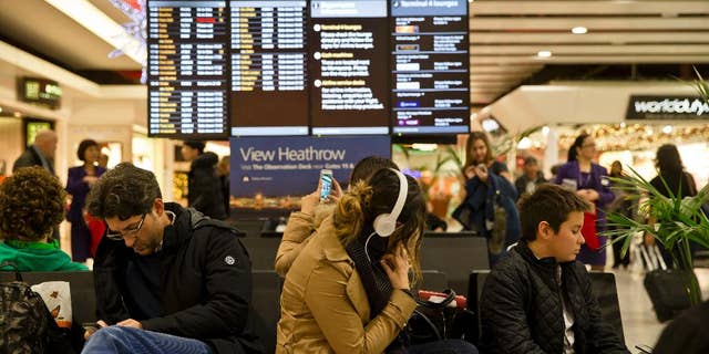 Passengers wait at Heathrow Airport in London, Friday, Dec. 12, 2014. London's airspace was closed today due to what authorities say was a computer failure at one of Britain's two air traffic control centres. Britain's national air traffic body says the computer problem that touched off troubles in the system has been fixed and it is in the process of returning to normal operations. (AP Photo/Vadim Ghirda)
