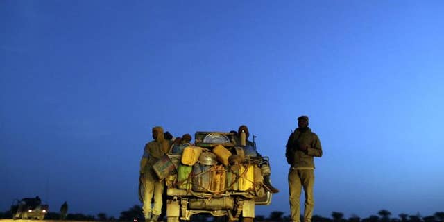 Malian soldiers patrol on a road between Kidal and Gao on July 29, 2013 in northern Mali.