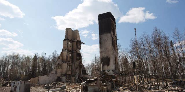 A burned building stands among charred rubble in the neighborhood of Abasand in wildfire-ravaged Fort McMurray, Alberta, on Friday, May 13, 2016. (Jason Franson /The Canadian Press via AP) MANDATORY CREDIT