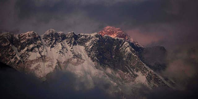 FILE - In this Oct. 27, 2011 file photo, the last light of the day sets on Mount Everest as it rises behind Mount Nuptse as seen from Tengboche, in the Himalaya's Khumbu region, Nepal. Human waste left by climbers on Mount Everest has become a problem that is causing pollution and threatening to spread disease on the world’s highest peak, chief of Nepal’s mountaineering association said Tuesday, March 3, 2015. Ang Tshering told reporters Tuesday that the more than 700 climbers and guides who spend nearly two months on Everest’s slopes each climbing season leave large amounts of feces and urine, and the issue has not been addressed. He said Nepal’s government needs to get the climbers to dispose of the waste properly so the mountain remains pristine. (AP Photo/Kevin Frayer, File)