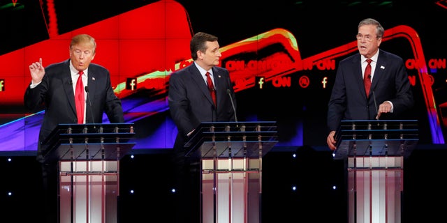 Donald Trump, a la izquierda, y Jeb Bush, a la derecha, hablan ante la mirada de Ted Cruz durante el debate republicano de CNN en el hotel y casino Venetian de Las Vegas, el martes 15 de diciembre de 2015 en Las Vegas. (AP Foto/John Locher)
