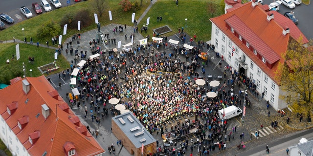 A crowd forms, those in the centre bathing in sunlight, for the official opening of giant sun mirrors in the town of Rjukan, Norway, Wednesday, Oct. 30, 2013. Residents of the small Norwegian town of Rjukan have finally seen the light. Tucked in between steep mountains, the town is normally shrouded in shadow for almost six months a year. But on Wednesday faint rays from the winter sun for the first time reached the market square thanks to three 183-square-foot (17-square-meter) mirrors placed on a mountain. (AP Photo/NTB Scanpix, Terje Bendiksby) NORWAY OUT
