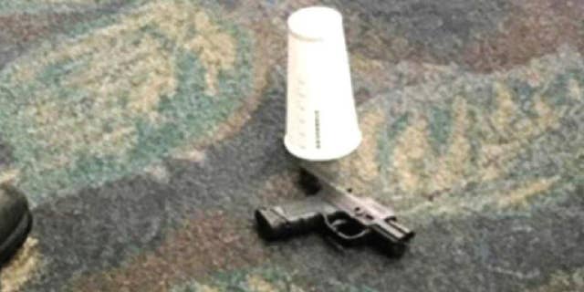 This photo taken Friday, Jan. 6, 2017 by passenger Mark Lea and released by Lea Sunday, Jan. 8 shows a handgun which was used by Iraq war veteran Esteban Santiago when he killed five people is seen on the floor at the scene of the attack at the Fort Lauderdale airport in Florida. In a post-9/11 world, American airports have taken all sorts of steps to keep travelers safe. But significant vulnerabilities remain. The attack that killed five people Friday at the Florida airport raised concerns about how to further protect travelers and what place firearms have in U.S. airports. (Mark Lea via AP)