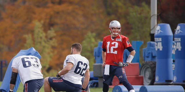 New England Patriots quarterback Tom Brady (12) stretches with offensive linemen Ryan Wendell (62) and Dan Connolly (63) before practice begins at the NFL football team's facility Wednesday, Oct. 29, 2014 in Foxborough, Mass. The Patriots (6-2) will play the Denver Broncos (6-1) Sunday in Foxborough. (AP Photo/Stephan Savoia)