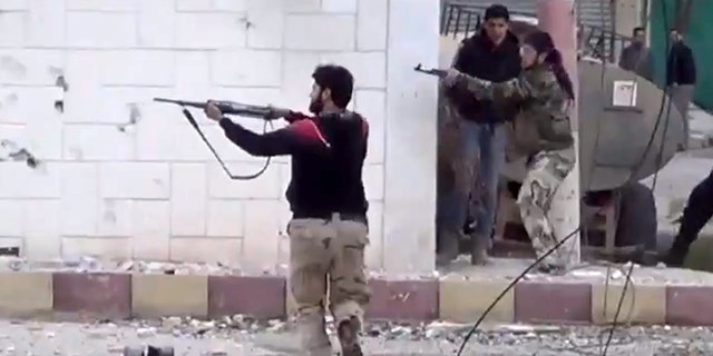FILE - In this Monday March 18, 2013 file image taken from video obtained from the Shaam News Network, which has been authenticated based on its contents and other AP reporting, shows free Syrian Army fighters fire at Syrian army soldiers during a fierce firefight in Daraa al-Balad, Syria. Syrian rebels captured a military base in the south and may be poised to seize control a strategically important region along the border with Jordan, something that would give them a critical gateway to attempt an attack on the capital Damascus. With foreign aid and training of rebels in Jordan ramping up, the opposition fighters have recaptured momentum and may also soon control Syria's side of the Golan Heights along a sensitive border with Israel. (AP Photo/Shaam News Network via AP video, File)