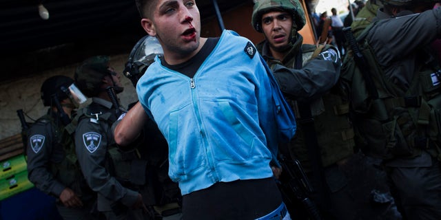 Israeli security forces detain a Palestinian man during clashes that erupted during a rally marking Nakba Day in Jerusalem, Wednesday, May 15, 2013. Palestinians annually mark the "nakba," or "catastrophe" — the term they use to describe their defeat and displacement in the war that followed Israel's founding in 1948. (AP Photo/Bernat Armangue)
