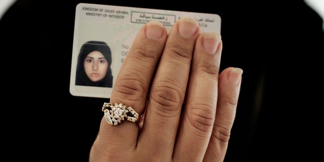 In this June 23, 2018 photo, a Saudi woman covering her name holds her new car license at the Saudi Driving School inside Princess Nora University in Saudi Arabia.
