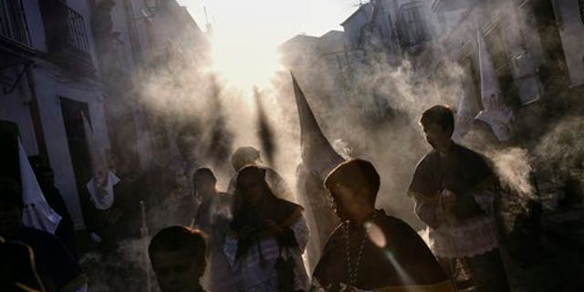 Smoke of burning incense flows while penitents take part in the "Estacion Penitencial de Nuestro Padre Jesus Nazareno Cautivo" Holy Week procession in Arriate, Spain, Thursday, April 2, 2015. Hundreds of processions take place throughout Spain during the Easter Holy Week. (AP Photo/Daniel Ochoa de Olza)