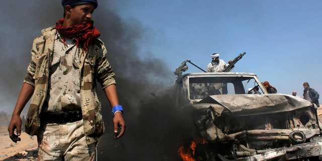 April 5: Libyan rebels inspect two destroyed military vehicles of pro-Qaddafi forces that rebels claim were targeted by a NATO strike along the front line near Brega, Libya.