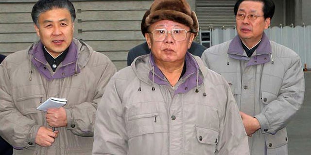 In this undated photo released by Korean Central News Agency via Korea News Service in Tokyo, North Korean leader Kim Jong Il, center, poses in front of the newly built Pothonggang Department Store in Pyongyang, North Korea.
