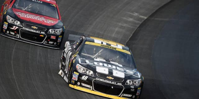 Jimmie Johnson, front, races in front of Mike Bliss during the NASCAR Sprint Cup series auto race, Sunday, Sept. 28, 2014, at Dover International Speedway in Dover, Del. Johnson finished the race in third place. (AP Photo/Nick Wass)