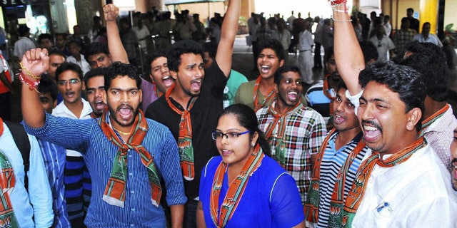 In this Friday, Nov. 29, 2013 photo, activists of the youth wing of India’s main opposition Bharatiya Janata Party shout slogans against Tarun Tejpal, editor of Tehelka magazine, ahead of his arrival at the airport in Panaji, India. The editor of the magazine known for exposing abuses of power has appeared in a court Saturday seeking bail to avoid arrest in a sexual assault case that has fueled fresh outrage over the treatment of women in India. (AP Photo)