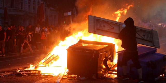 July 7: Protestors are silhouetted against a fire during demonstrations against the G-20 summit Hamburg