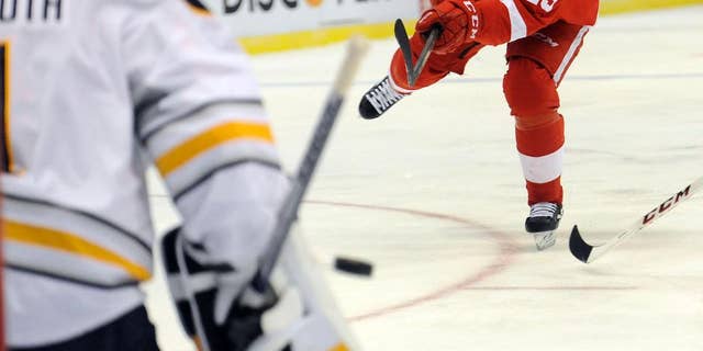 Detroit Red Wings center Pavel Datsyuk (13) of Russia, right, shoots the puck at Buffalo Sabres goalie Jhonas Enroth (1) of Sweden in the first period of an NHL hockey game at Joe Louis Arena in Detroit, Sunday, Jan. 18, 2015.  (AP Photo/Jose Juarez)