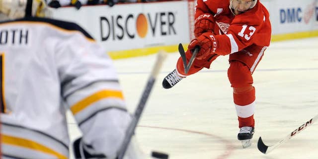 Detroit Red Wings center Pavel Datsyuk (13) of Russia, right, shoots the puck at Buffalo Sabres goalie Jhonas Enroth (1) of Sweden in the first period of an NHL hockey game at Joe Louis Arena in Detroit, Sunday, Jan. 18, 2015. (AP Photo/Jose Juarez)