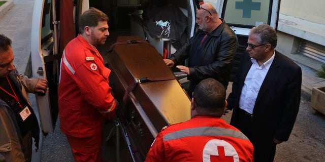 Lebanese Red Cross workers carry the coffin of British doctor Abbas Khan, 32, who was seized by Syrian government troops in November 2012, into the Hotel-Dieu de France hospital in Beirut, Lebanon, Saturday, Dec. 21, 2013. The circumstances in which Khan, died while in detention in Syria remain in dispute. A senior British official has accused Syrian President Bashar Assad's government of effectively murdering Khan, while the Syrian authorities say the doctor committed suicide and there was no sign of violence or abuse. (AP Photo/Bilal Hussein)