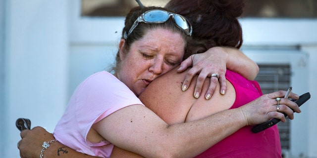 Carrie Matula embraces a woman after a fatal shooting at the First Baptist Church.