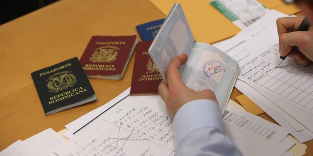 NEW YORK, NY - JANUARY 31: An immigration lawyer sorts through an immigrant's valid and expired passports from the Dominican Republic on January 31, 2013 in New York City. Lemons works at the CUNY Citizenship Now "Express Center" in New York's Washington Heights. The non-profit helps some 8,000 immigrants in the New York area navigate through the complicated process of acquiring U.S. Citizenship and provides free legal information for the immigrant community. (Photo by John Moore/Getty Images)