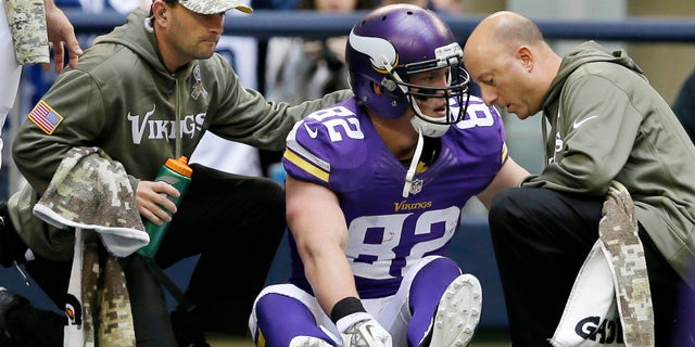 Minnesota Vikings' Kyle Rudolph (82) is attended to by staff after Rudolph scored on a pass play in the second half of an NFL football game against the Dallas Cowboys, Sunday, Nov. 3, 2013, in Arlington, Texas. (AP Photo/Tim Sharp)
