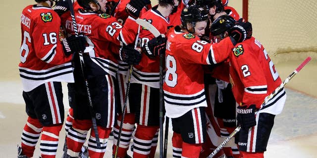 Chicago Blackhawks defenseman Duncan Keith, right, celebrates with teammates after they defeated the Nashville Predators 4-3 in Game 6 of an NHL Western Conference hockey playoff series Saturday, April 25, 2015, in Chicago. (AP Photo/Nam Y. Huh)