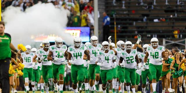 The Oregon football team runs onto the field for an NCAA college football game against South Dakota in Eugene, Ore., Saturday, Aug. 30, 2014. (AP Photo/Ryan Kang)
