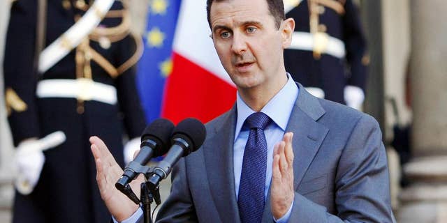 FILE - In this Thursday Dec. 9, 2010 file photo, Syria President Bashar al-Assad addresses reporters following his meeting with French President Nicolas Sarkozy at the Elysee Palace in Paris, France. Paris prosecutors have opened a preliminary investigation into French government accusations that Syrian President Bashar Assad's government has committed crimes against humanity. The prosecutor's office said Wednesday the investigation is based on photos taken by a former Syrian officer who fled in 2013 and focuses on atrocities allegedly committed between 2011 and 2013. (AP Photo/Remy de la Mauviniere, File)