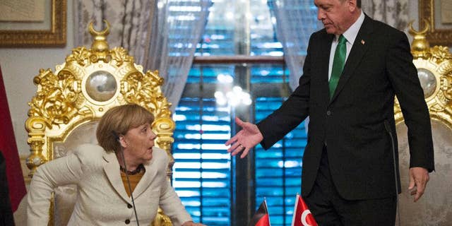 Turkish President Recep Tayyip Erdogan, right, offers his hand to shake hands with Germany's Chancellor Angela Merkel, left, following a joint statement after their meeting in Istanbul, Sunday, Oct. 18, 2015. Merkel met with Turkish leaders to promote a EU plan that would offer aid and concessions to Turkey in exchange for measures to stem the mass movement of migrants across Europe's borders. (Tolga Bozoglu, Pool Photo via AP)