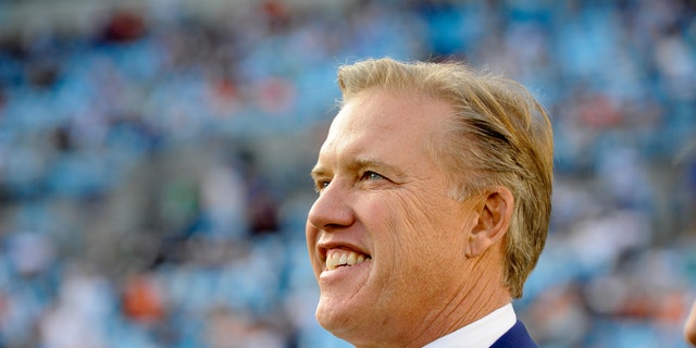 FILE - This is a Nov. 11, 2012 file photo showing Denver Broncos executive vice president, John Elway, watching players warm up prior to an NFL football game between the Carolina Panthers and the Denver Broncos in Charlotte, N.C. Elway could very well be directing his greatest comeback from a leather chair in an office. (AP Photo/Mike McCarn, File)