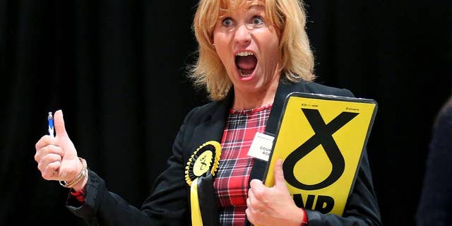 A Scottish National Party (SNP) election canvasser reacts as she views ballot papers being counted for the Banff and Buchan, Gordon, and West Aberdeenshire and Kincardine constituency counts in Britain's election at the Aberdeen Exhibition and Conference Centre in Aberdeen, Scotland Friday May 8, 2015. (Andrew Milligan/PA via AP) UNITED KINGDOM OUT, NO SALES, NO ARCHIVE