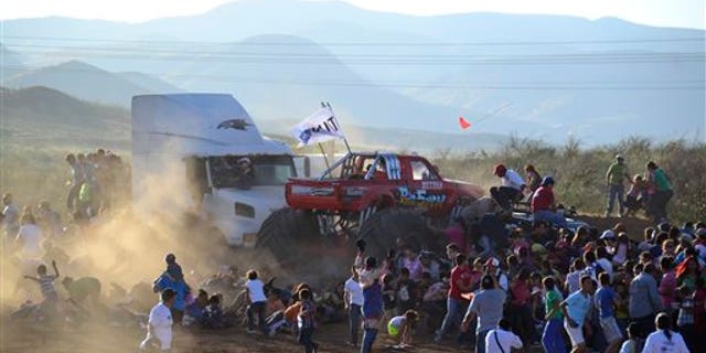 People run as an out of control monster truck plows through a crowd of spectators in the city of Chihuahua, Mexico, Saturday Oct. 5, 2013.