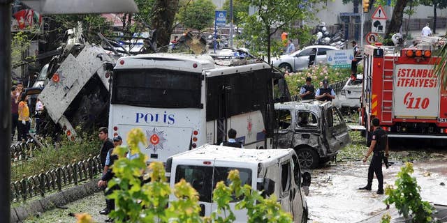 Turkish security officials and firefighters at the site of a bus explosion Tuesday.