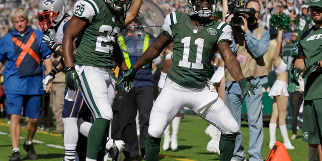 New York Jets wide receiver Jeremy Kerley (11) and Bilal Powell (29) celebrate a touchdown by Kerley during the first half of an NFL football game against the New England Patriots Sunday, Oct. 20, 2013 in East Rutherford. (AP Photo/Seth Wenig)