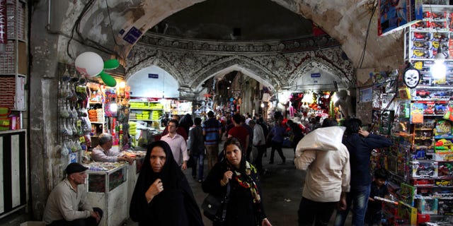 Iranians walk in the old bazaar, in Tehran, Iran, on Sunday, May 12, 2013. On Saturday former President Akbar Hashemi Rafsanjani's made a last minute surprise decision to enter Iran's presidential election process, which now includes more than 680 hopefuls and will culminate June 14 with just a handful of names on the ballot to succeed Mahmoud Ahmadinejad. In one of his first statements since joining the race, Rafsanjani spoke in general terms Sunday of seeking a new ``economic and political'' rebirth in a time of ``foreign threats and sanctions.'' (AP Photo/Vahid Salemi)