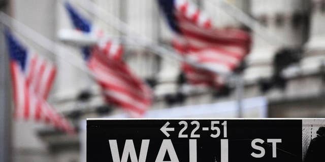 FILE - This April 22, 2010, file photo, shows a Wall Street sign in front of the New York Stock Exchange. Global stock markets were subdued on Tuesday, Sept. 9, 2014, but the dollar hit a six-year high against the yen on investor expectations the Federal Reserve will end stimulus and raise interest rates in coming months. (AP Photo/Mark Lennihan, File)
